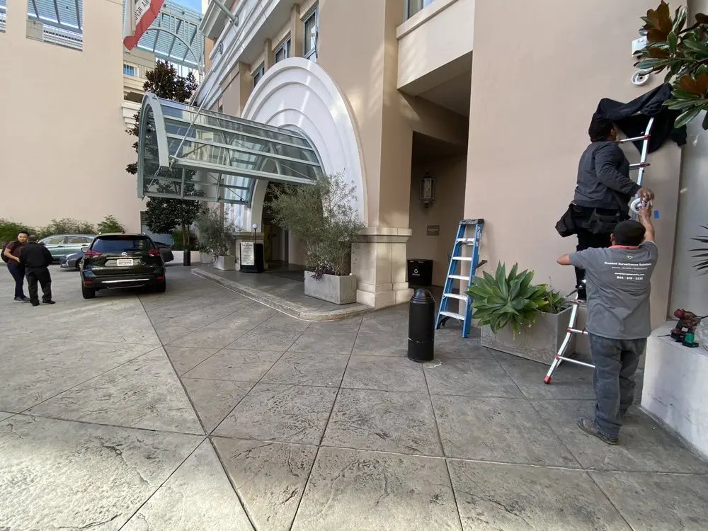 Technicians updating security cameras at a hotel entrance